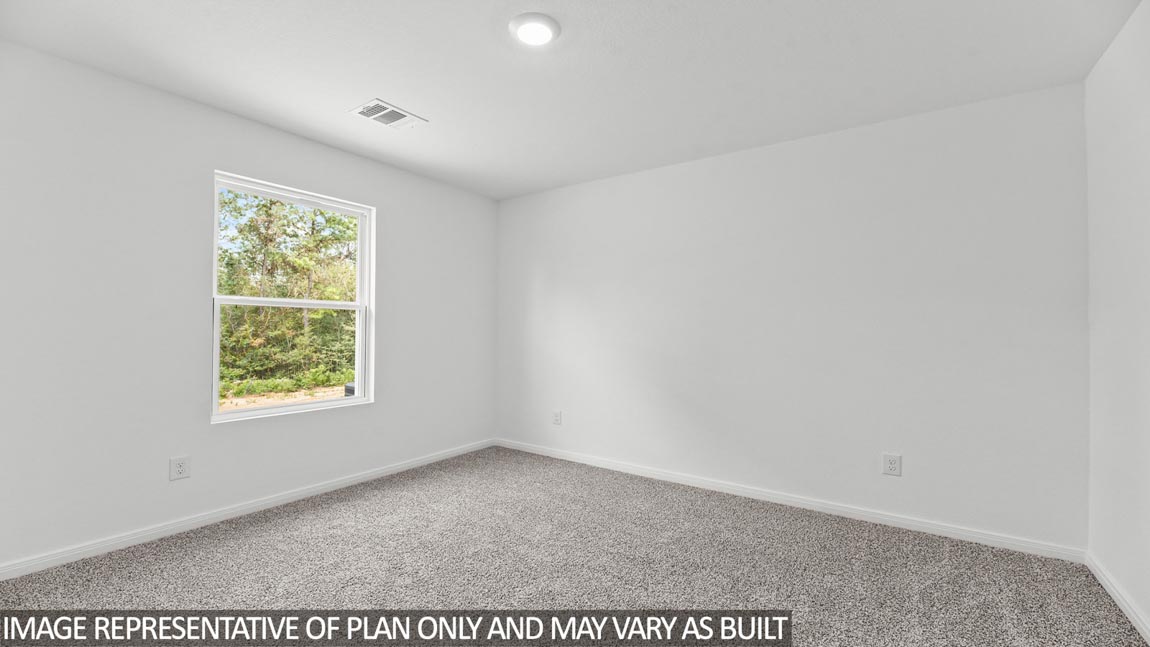 Secondary bedroom with carpet flooring