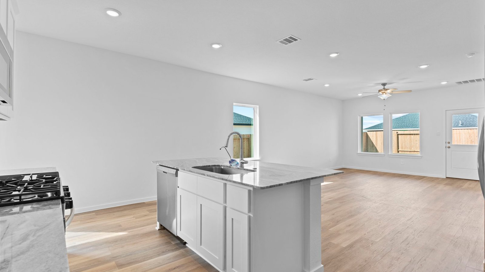 kitchen with white cabinets, stainless steel appliances and island with sink