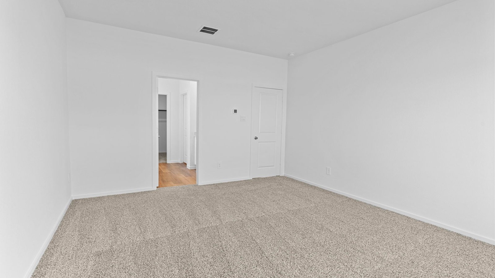 primary bedroom with two windows and carpet