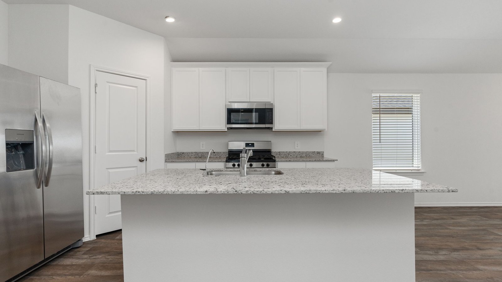Kitchen with white cabinets RVP flooring and island with sink