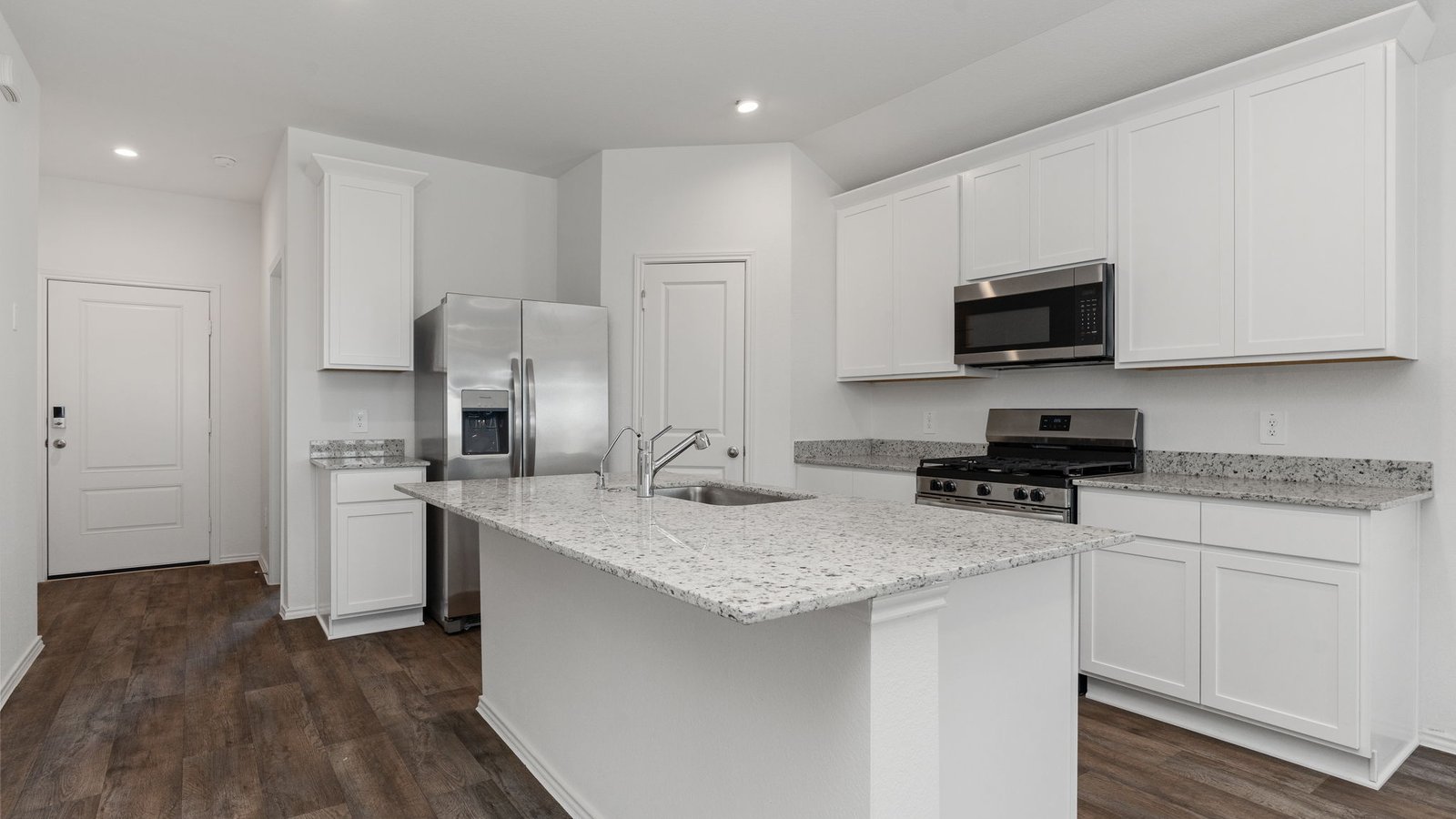 Kitchen with white cabinets RVP flooring and island with sink