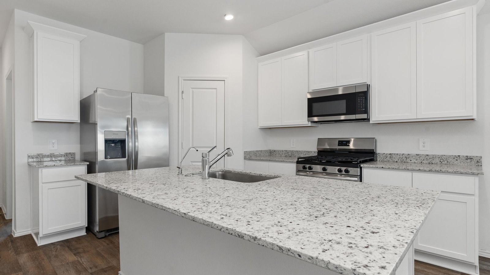 Kitchen with white cabinets RVP flooring and island with sink