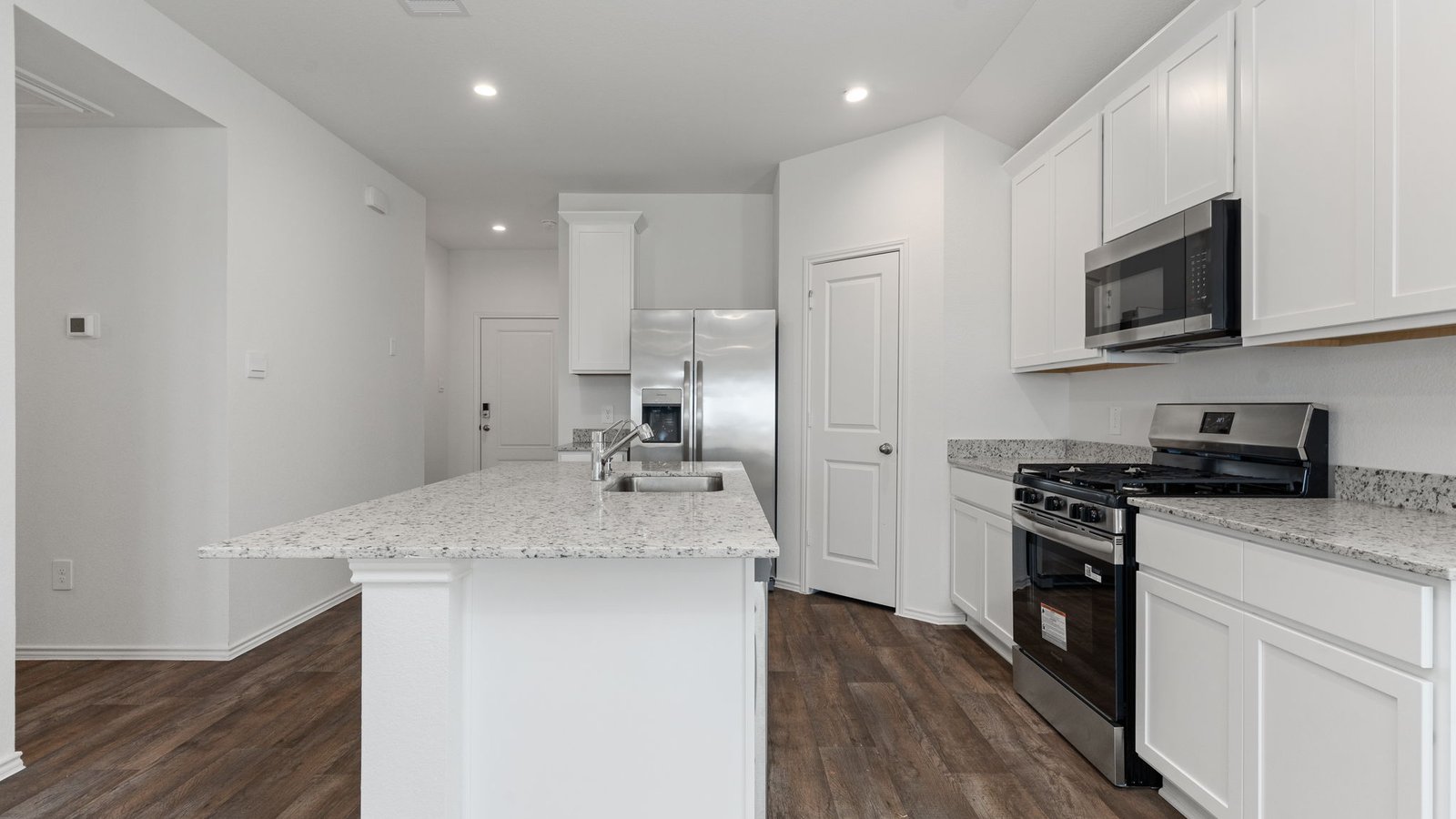 Kitchen with white cabinets RVP flooring and island with sink