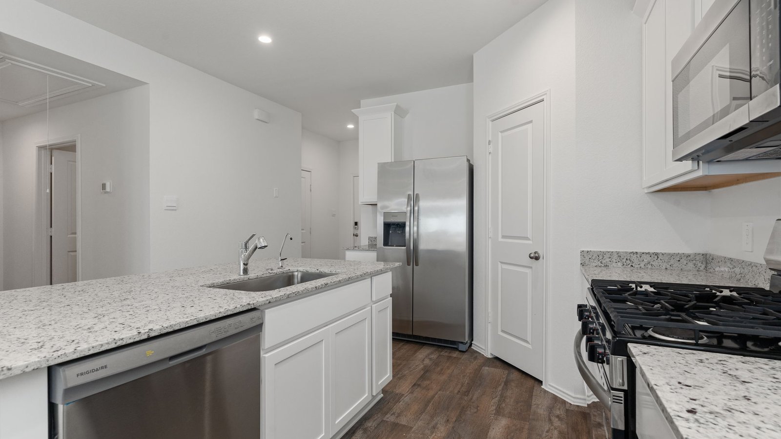 Kitchen with white cabinets RVP flooring and island with sink