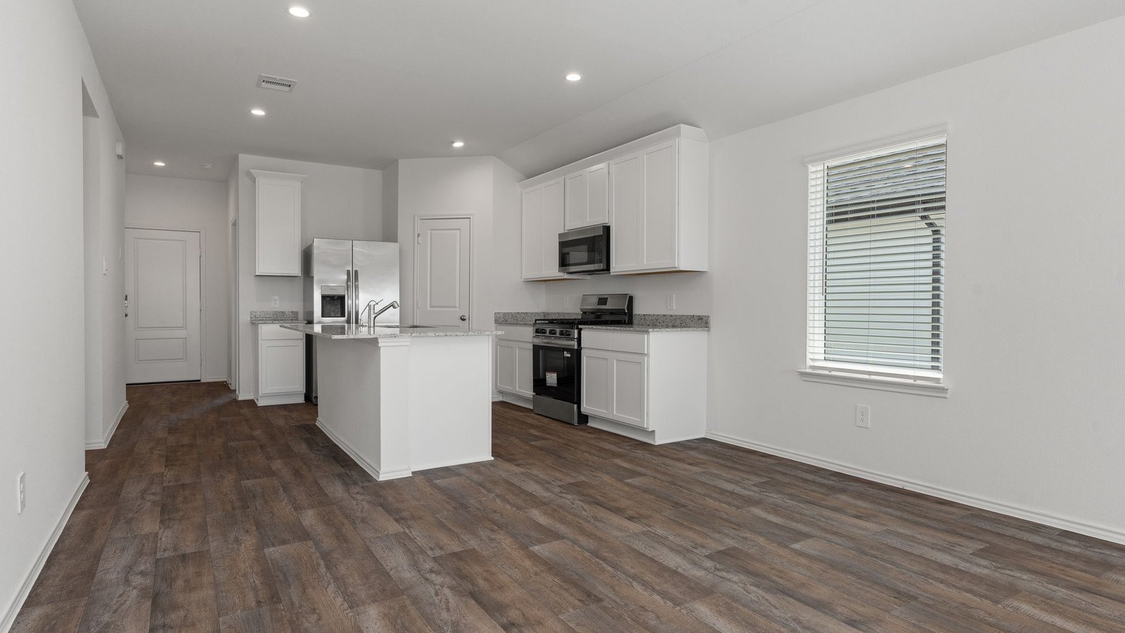 Kitchen with white cabinets RVP flooring and island with sink