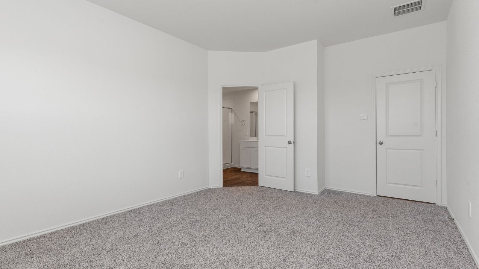 primary bedroom with two windows and carpet