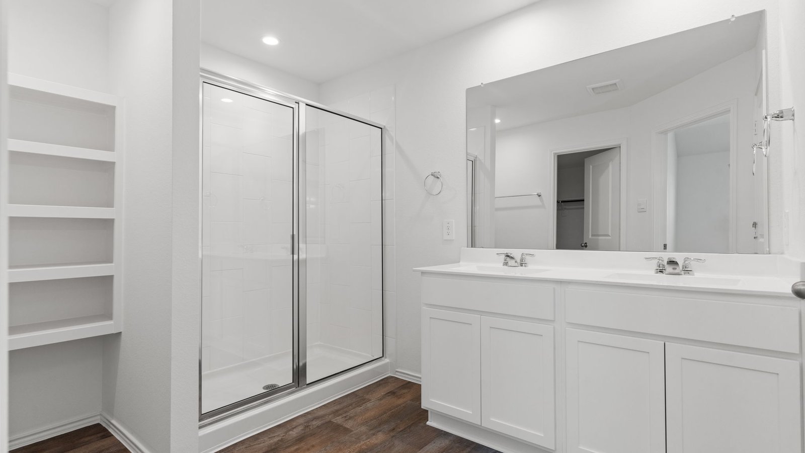 primary bathroom with dial vanity sinks, standing shower, and storage shelves