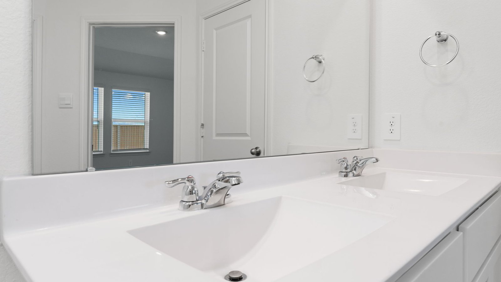 primary bathroom with dial vanity sinks, standing shower, and storage shelves