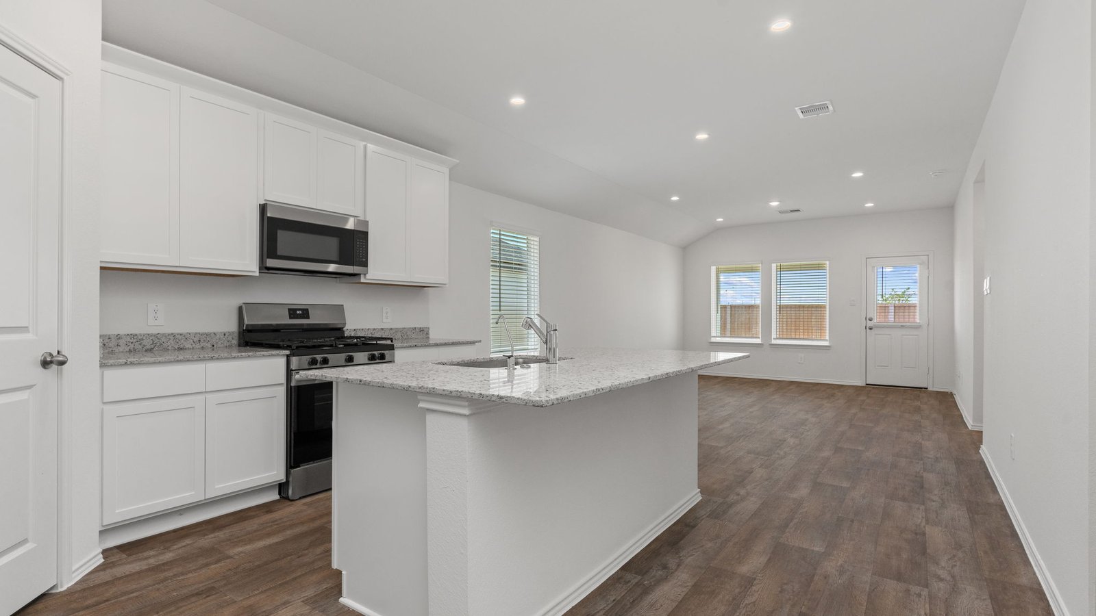 Kitchen with white cabinets RVP flooring and island with sink