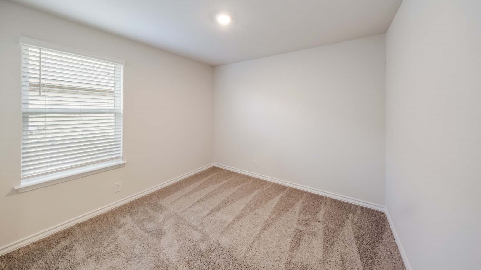 Guest bedroom 2 with side window and plush carpet floor