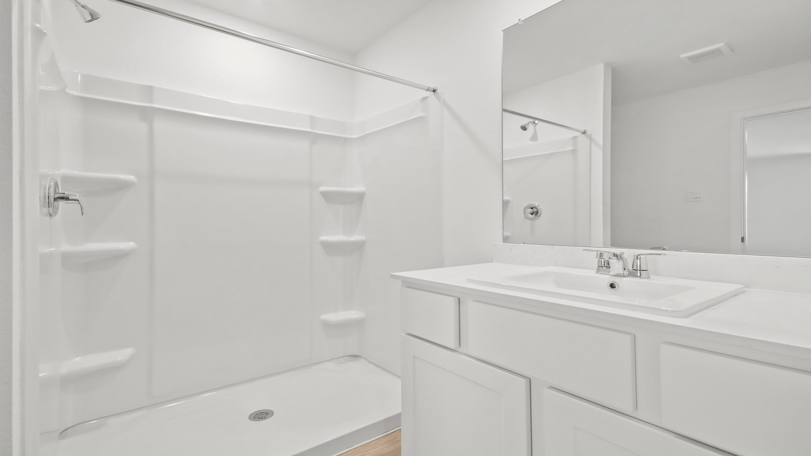 Private attached primary bathroom with built in vanity and luxurious shower