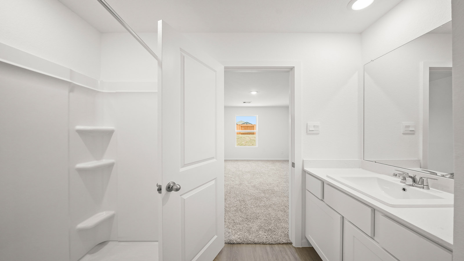 Private attached primary bathroom with built in vanity and luxurious shower