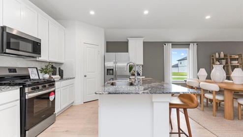 kitchen with white cabinets and waterfall countertops