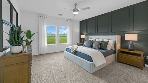 primary bedroom with accent wall and natural lighting