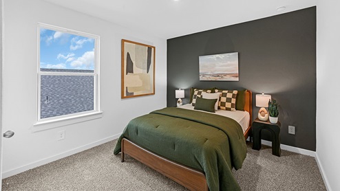 guest bedroom with window and accent wall