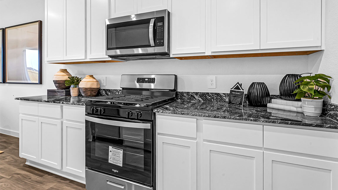 Open concept kitchen with stainless steel appliances, shaker style cabinets, and elevated finishes