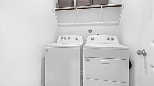 laundry room with hanging rack, washer, and dryer