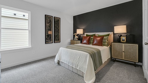 secondary bedroom with window and accent wall