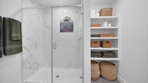 primary bedroom bathroom with shelves and stand up shower