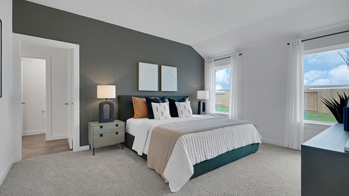 modern minimalistic primary bedroom with windows and high ceiling with door leading to living area
