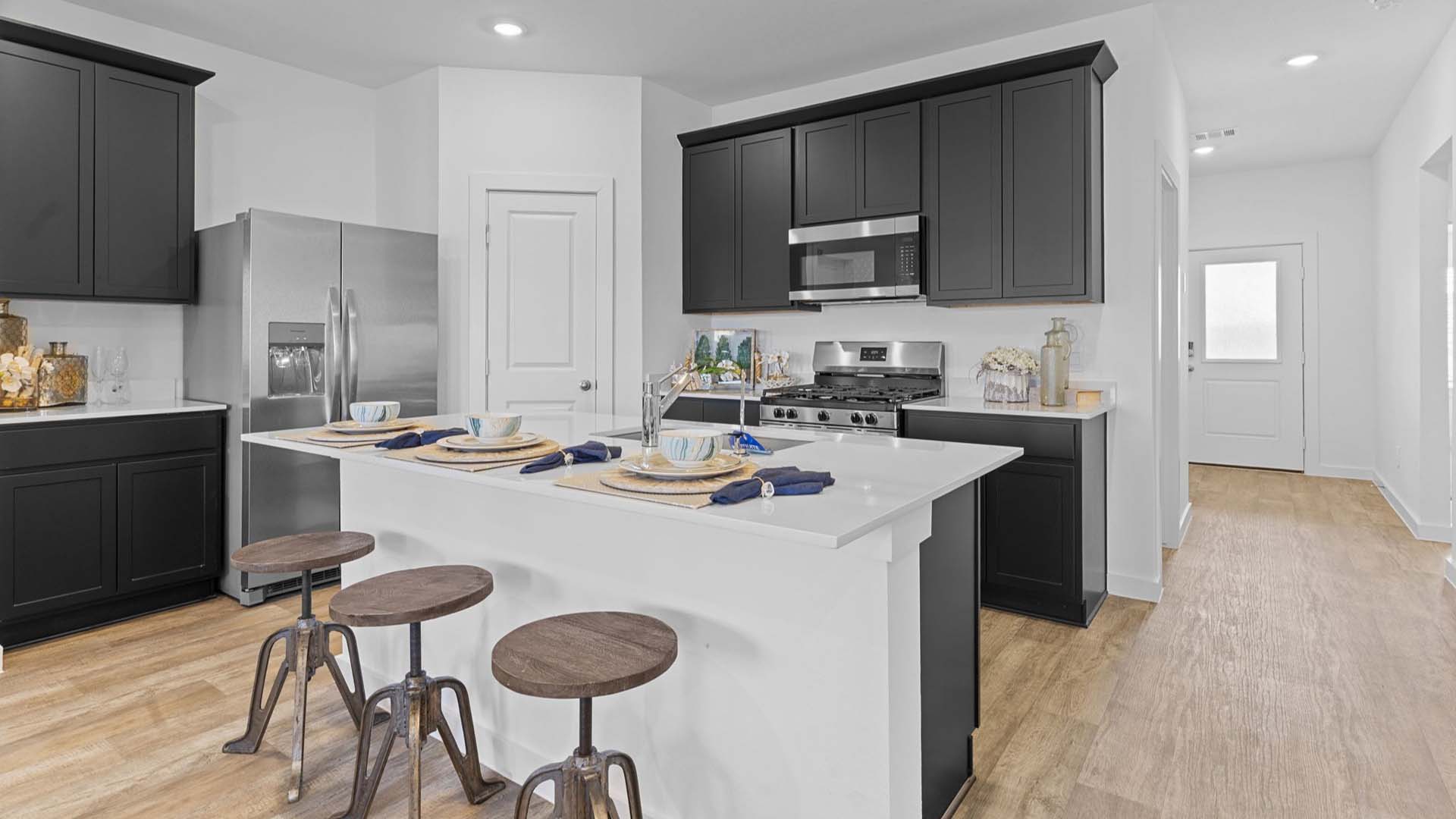 Open concept kitchen with stainless steel appliances, shaker style cabinets, and elevated finishes