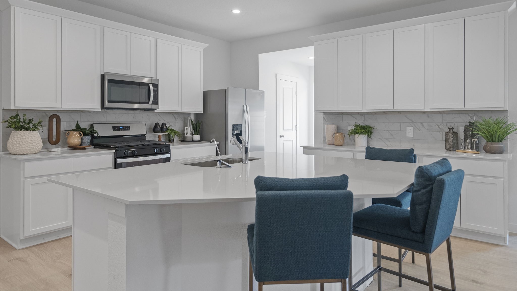 Open concept kitchen with stainless steel appliances, shaker style cabinets, and elevated finishes