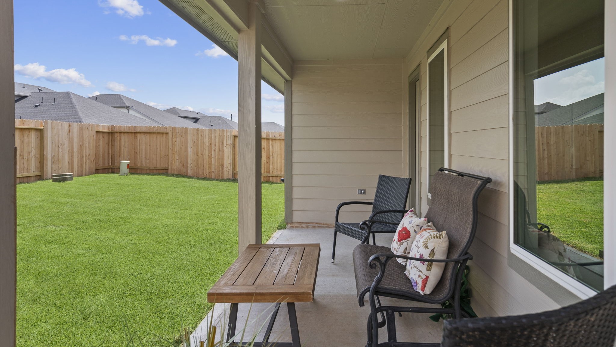 Covered back patio area overlooking private fenced-in backyard
