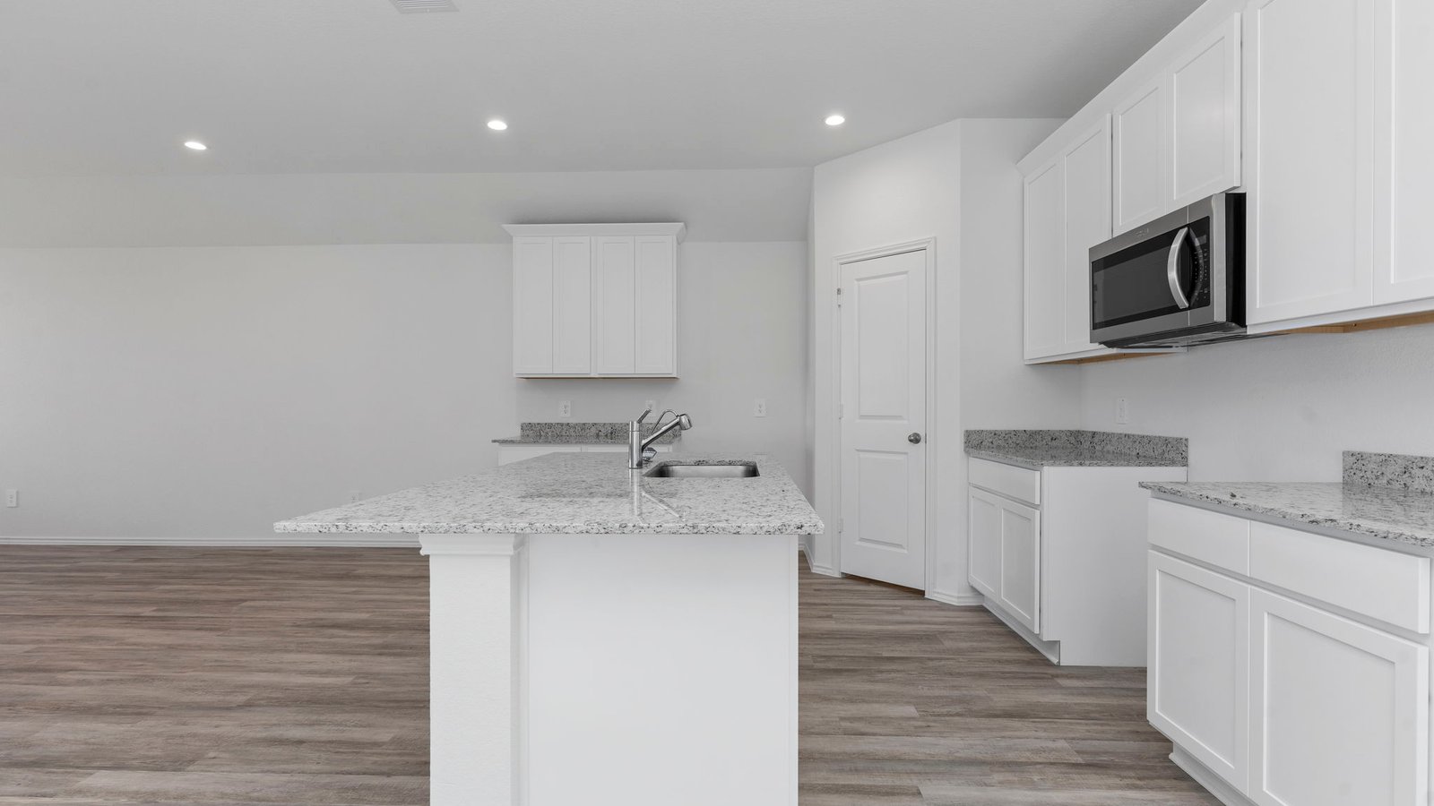 Open concept kitchen with stainless steel appliances, shaker style cabinets, and elevated finishes