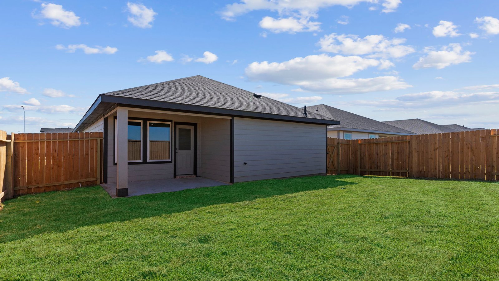 Covered back patio area overlooking private fenced-in backyard