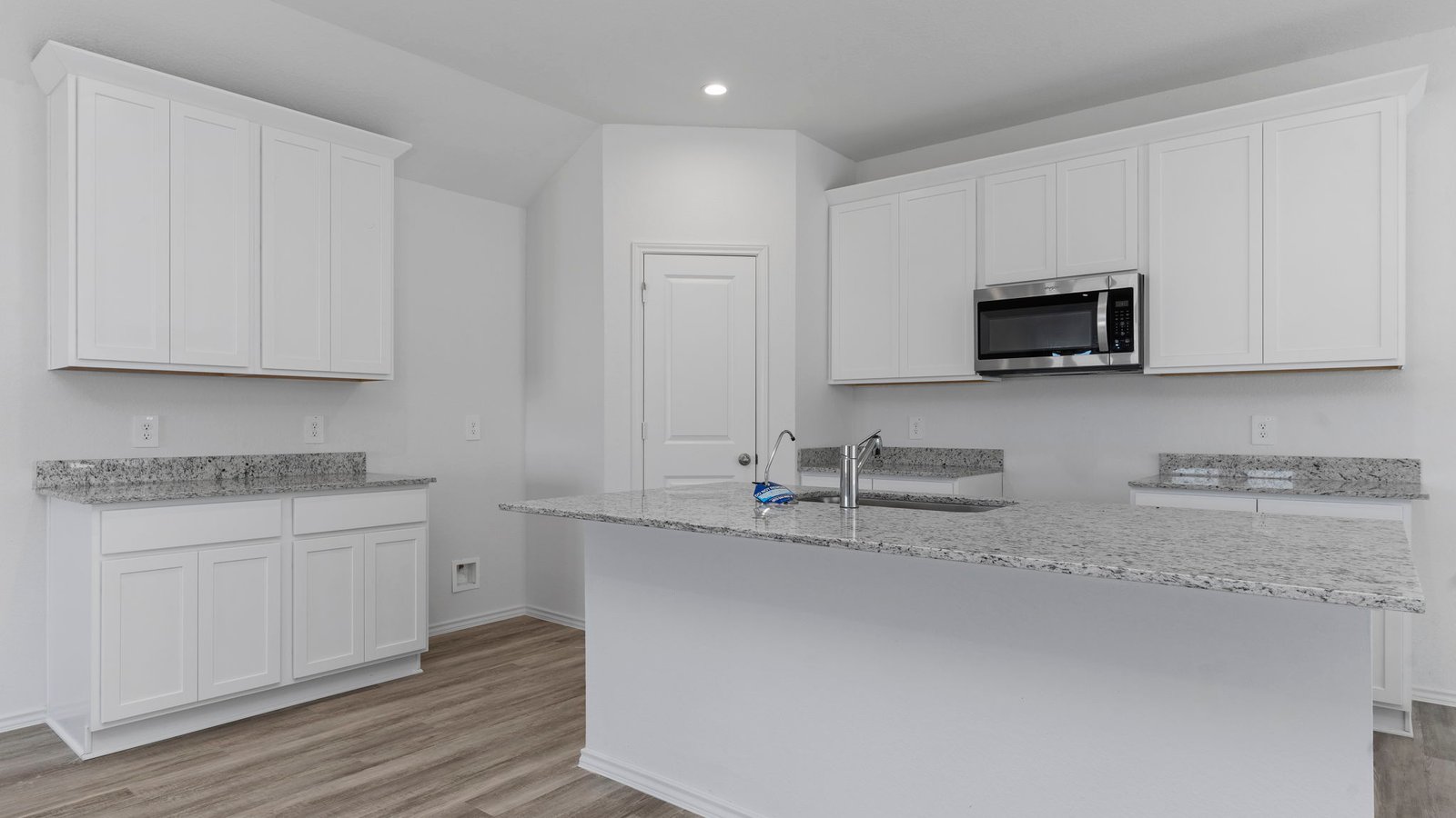 Open concept kitchen with stainless steel appliances, shaker style cabinets, and elevated finishes