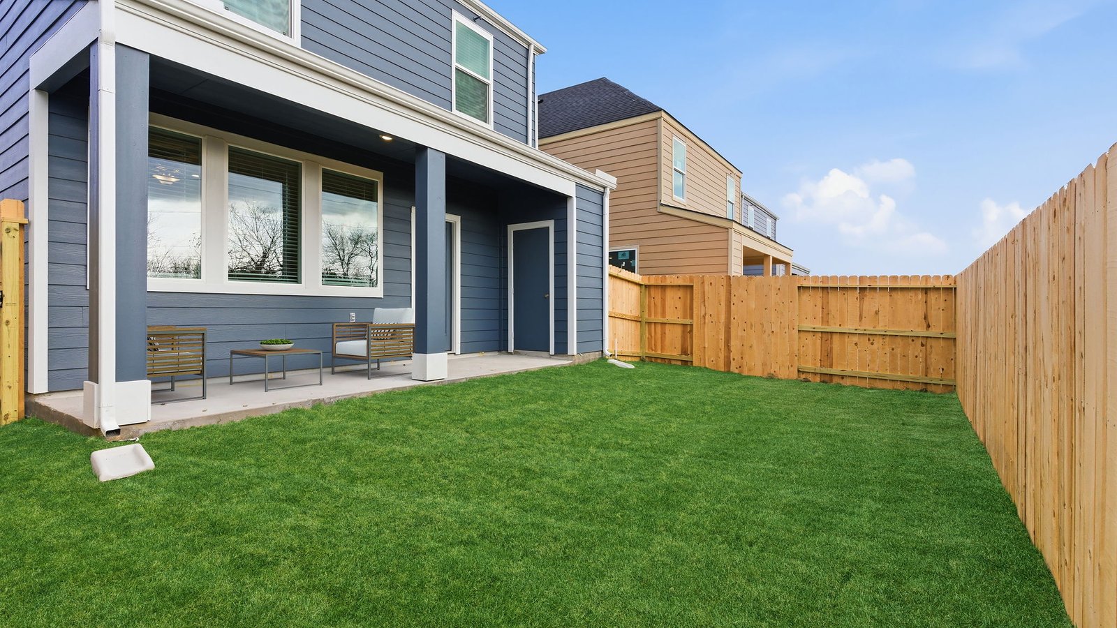 Covered back patio area overlooking private fenced-in backyard