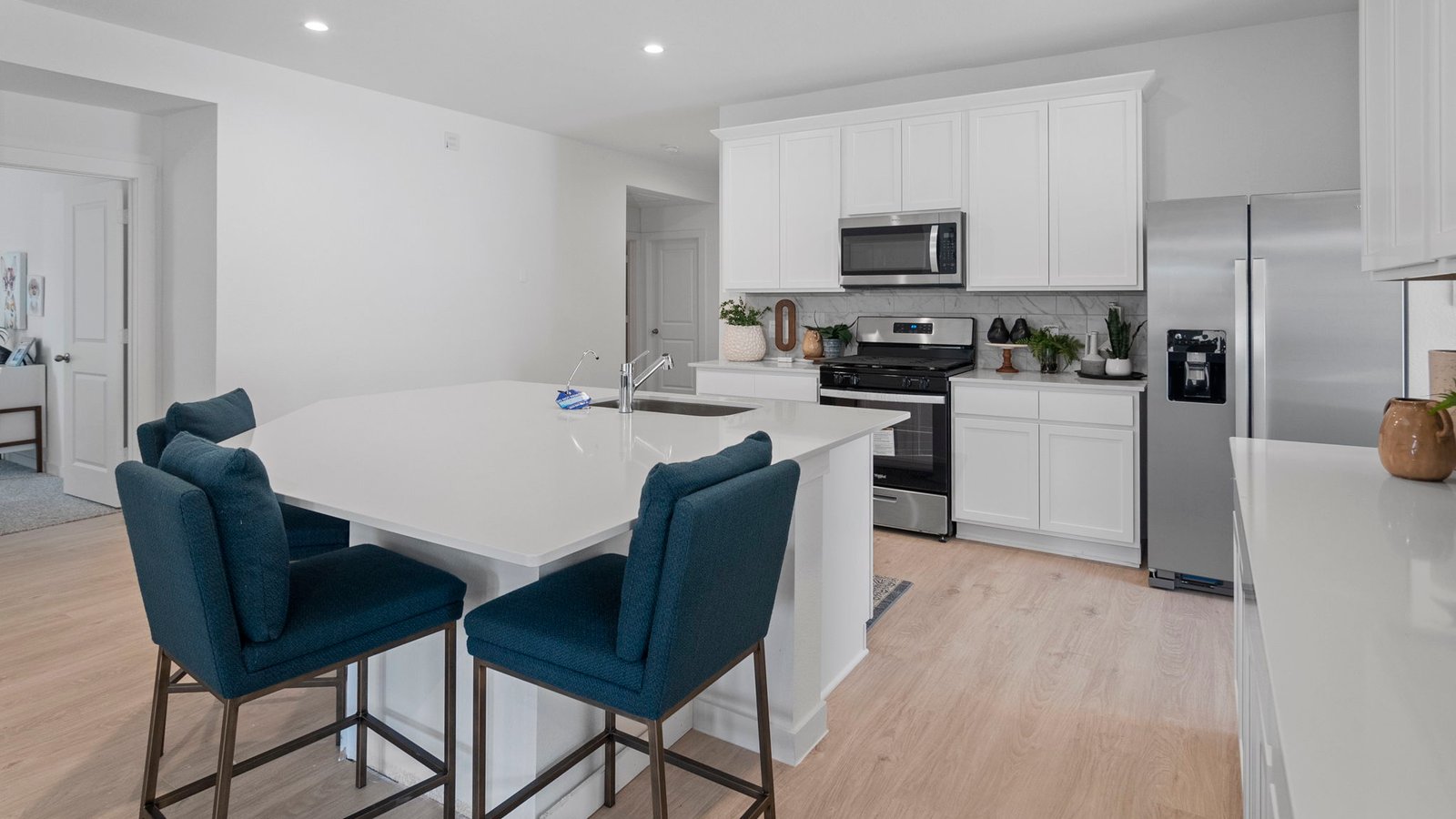 Open concept kitchen with stainless steel appliances, shaker style cabinets, and elevated finishes