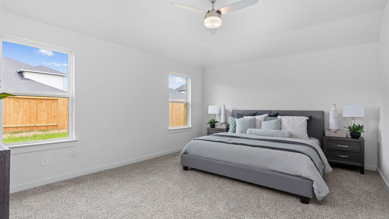 Primary bedroom with plush carpet floors and light allowing double windows