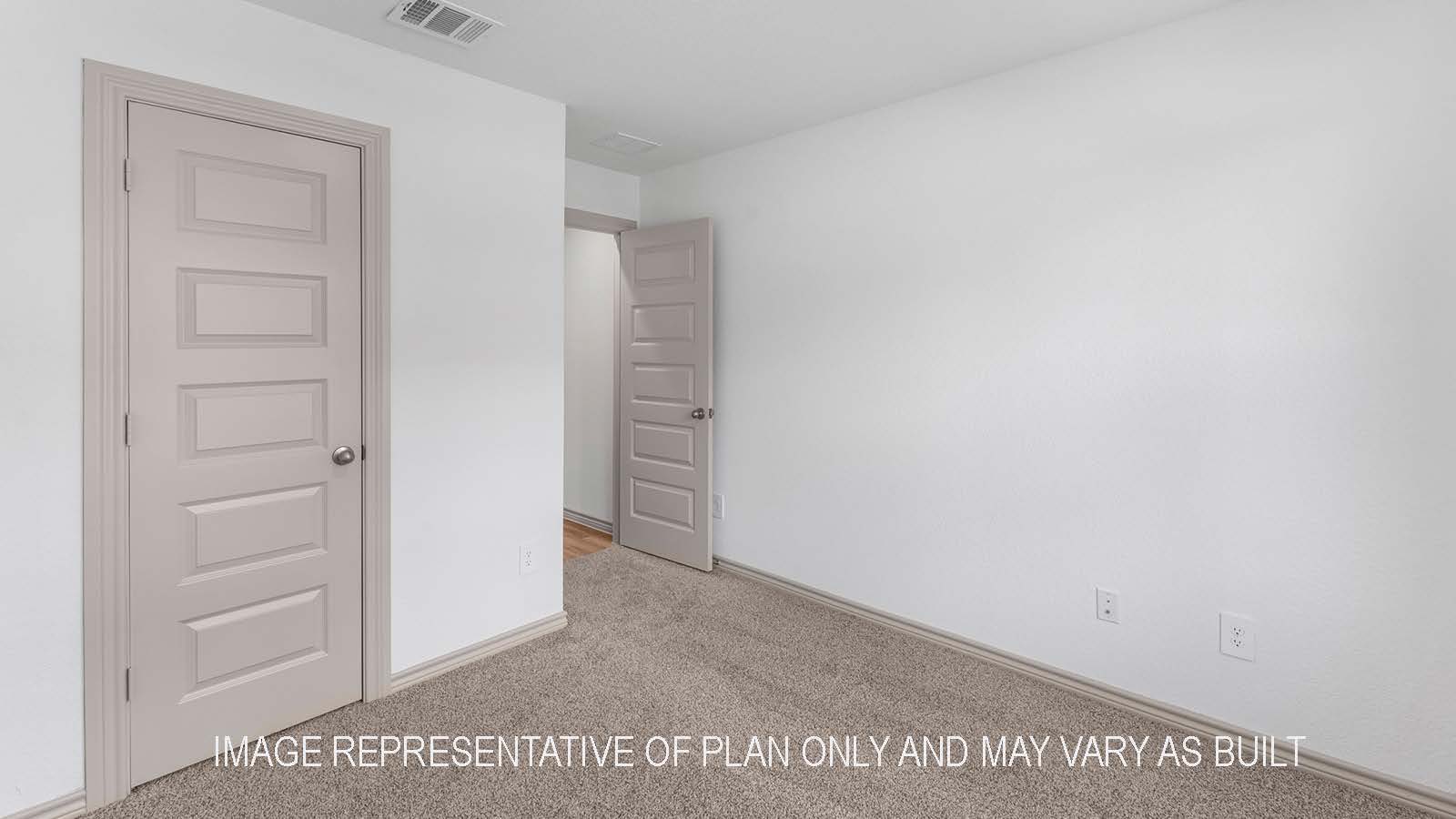 Camden secondary bedroom with carpet flooring and closet door.