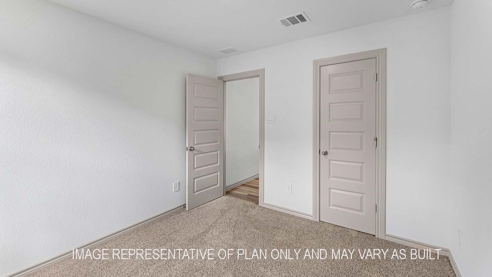 Camden secondary bedroom with carpet flooring and closet door.