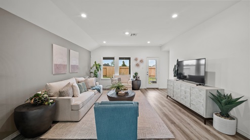 Reserve at Mallard Lakes model home living room with vinyl plank flooring and view to backyard.