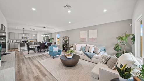 Reserve at Mallard Lakes model home living room with vinyl plank flooring and view to kitchen and dining.