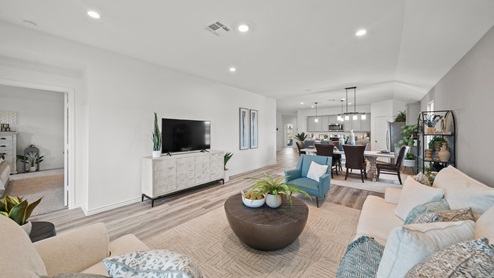 Reserve at Mallard Lakes model home living room with vinyl plank flooring and light furniture.