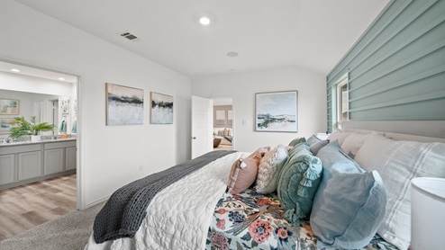 Reserve at Mallard Lakes model home primary bedroom with painted shiplap wall detail and furniture.