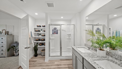 Reserve at Mallard Lakes model home primary bathroom with gray cabinets and granite countertops.