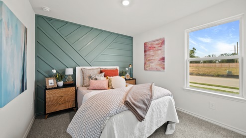 Reserve at Mallard Lakes model home secondary bedroom with shiplap wall detail and carpet flooring.