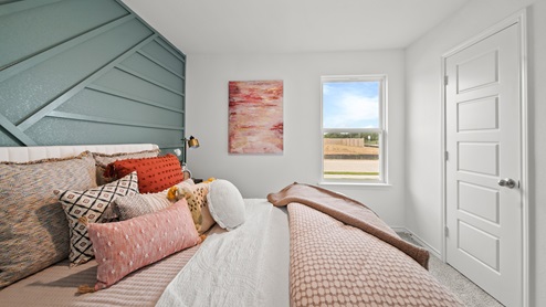 Reserve at Mallard Lakes model home secondary bedroom with shiplap wall detail and carpet flooring.