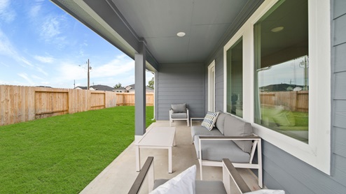 Reserve at Mallard Lakes model home back porch with patio furniture and landscaped yard.