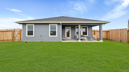 Reserve at Mallard Lakes model home back porch with patio furniture and landscaped yard.