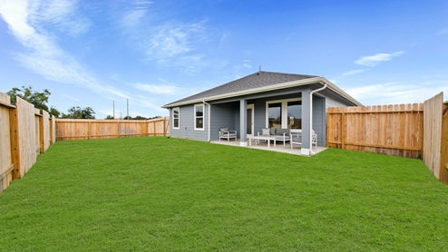 Reserve at Mallard Lakes model home back porch with patio furniture and landscaped yard.
