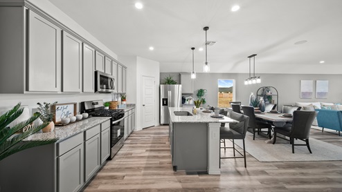 Reserve at Mallard Lakes model home open kitchen with gray cabinets and spacious island.