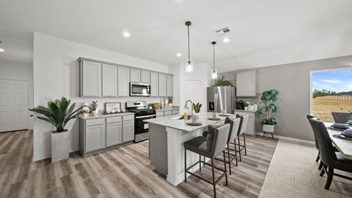 Reserve at Mallard Lakes model home open kitchen with gray cabinets and spacious island.