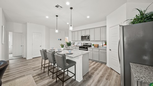 Reserve at Mallard Lakes model home open kitchen with gray cabinets and spacious island.