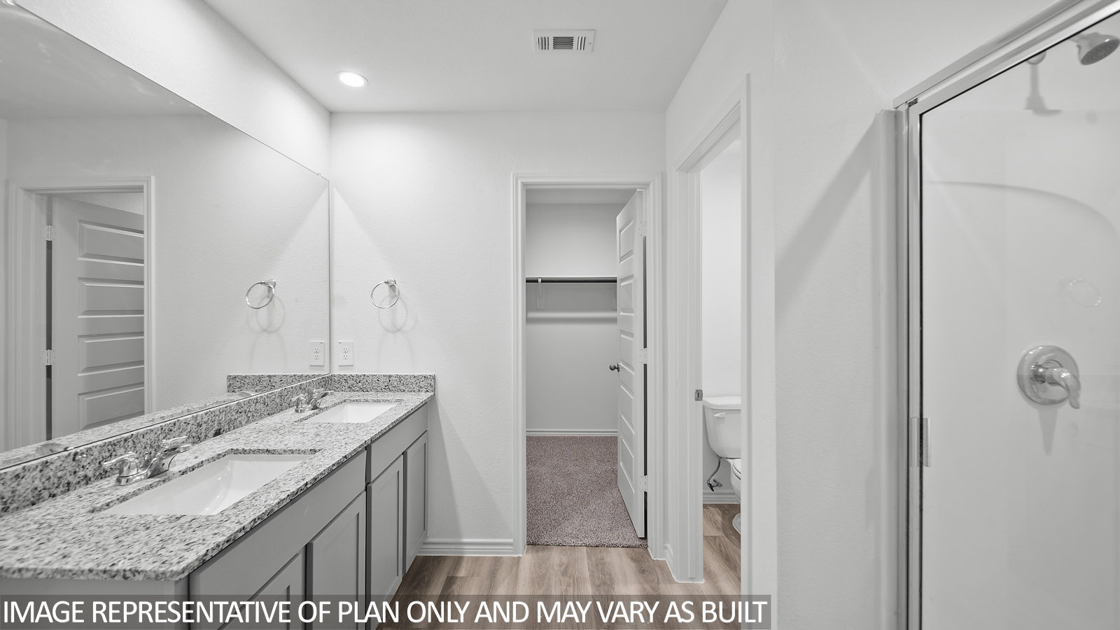 Baxtor primary bathroom with gray cabinets and granite countertops and walk-in shower.