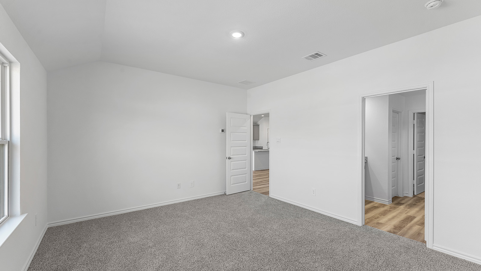 Harris primary bedroom carpet flooring and view of the primary bathroom.